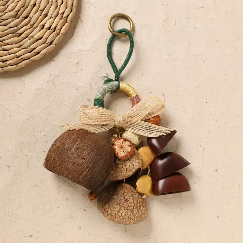 A minimalist flat-lay of the natural nut shell charm on a beige textured background. Kinds of shells, topped with a delicate jute bow, exhibit a Japandi and Zen-inspired aesthetic