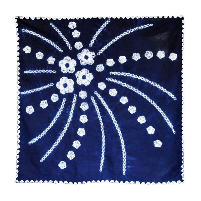 Close-up of a deep indigo blue square cloth with white hand-dyed cascading floral patterns, artisanal tie-dye technique from Yunnan.