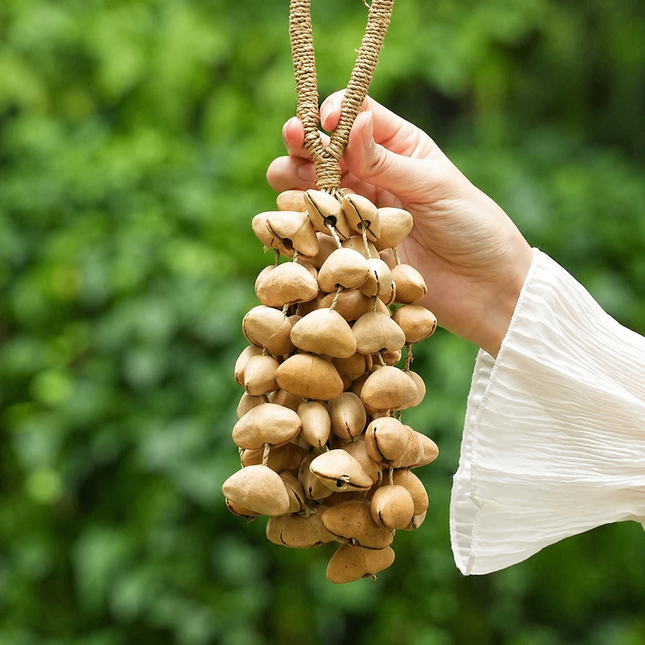 Handheld Chacha shell shaker with a serene lakeside background, highlighting the light brown texture of the natural percussion instrument.